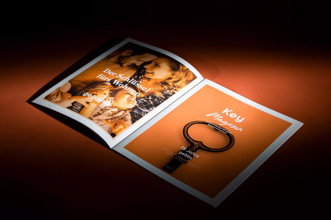 Aufgeschlagenes Key Magazin von Gebös mit Familienfoto, altem Schlüssel und Titel „75 Jahre gebös“
